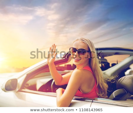 Foto d'archivio: Happy Young Woman In Convertible Car Waving Hand