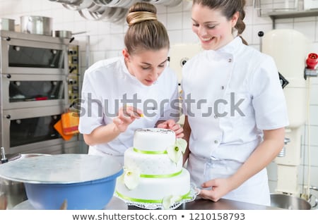 Stock fotó: Two Pastry Bakers Decorating Large Cake