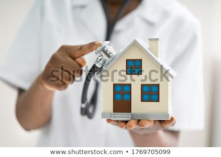 Сток-фото: Doctor Using Stethoscope To Check Model House