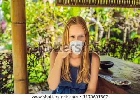Stock photo: Young Woman Drinks Coffee Luwak In The Gazebo