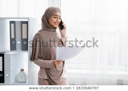 Foto stock: Young Muslim Female Consulting Clients On The Phone And Online