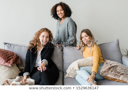 Foto stock: Group Of Cheerful Friendly Girls Relaxing On Soft Comfortable Sofa