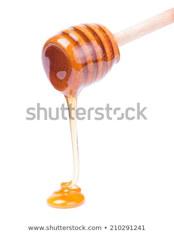 Foto stock: Fragrant Organic Fresh Honey Dripping From Wooden Stick To A Glass Pot On A Gray Marble Table Pure