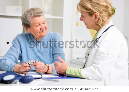 Stockfoto: Doctor Or Nurse Explaining Prescription Medicine To Senior Adult