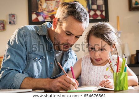 Foto stock: Cheerful Father Helping Her Daughter For Homework