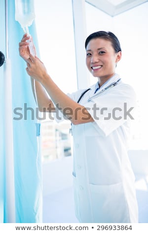 Stok fotoğraf: Concentrated Female Doctor Connecting An Intravenous Drip