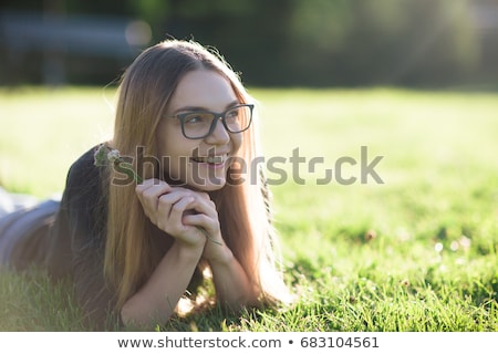 Stock photo: Portrait Of A Cute Young Girl Laying On A Grass At The Park