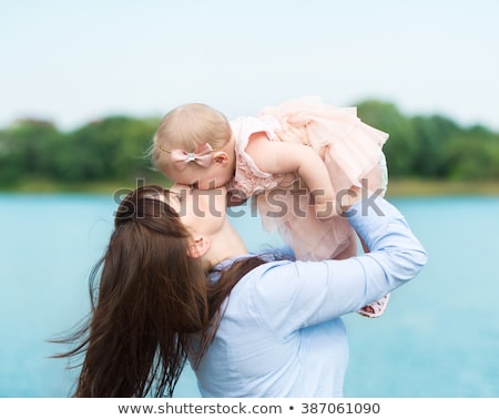 Foto stock: Happy Smiling Mother Hugging Daughter Over Sky