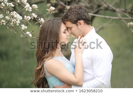 Stok fotoğraf: A Kissing Newlywed Couple Spending Time In Blooming Garden