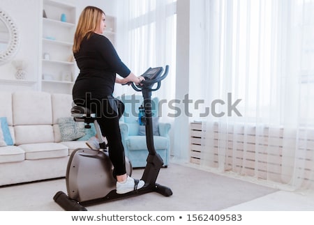 Stock fotó: Overweight Woman Exercising On Bike