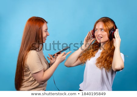 [[stock_photo]]: Redhead Woman Listening Music On Smartphone At Home