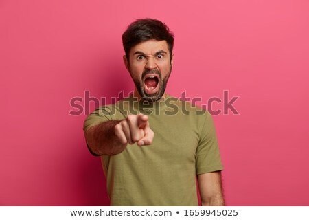 Foto d'archivio: Mad Irritated Young Man Shouting And Pointing On You