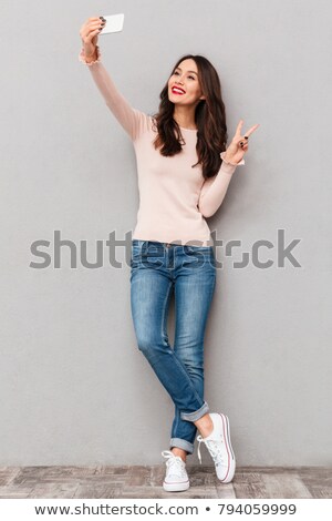 [[stock_photo]]: Full Length Shot Of Young Smiling Girl Showing At Copy Space