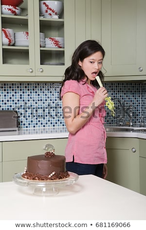 ストックフォト: Young Woman Eating Celery Watching Chocolate Cake