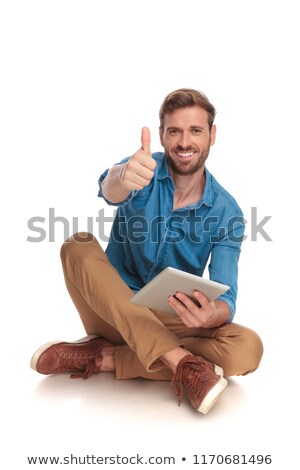 Stock photo: Seated Casual Man Working On Tablet Makes The Ok Sign