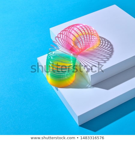 Foto stock: Rainbow Plastic Slinky Toy With Duotone Shadows