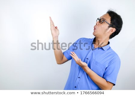 ストックフォト: Young Asian Man War Blue Shirt Is Surprised And Shouting Wow With Pointing Right With His Finger Iso