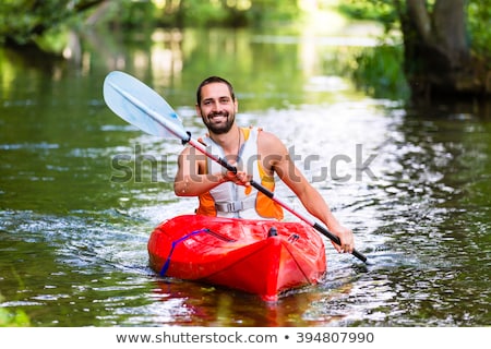 年輕人在河中劃獨木舟 商業照片 © Kzenon