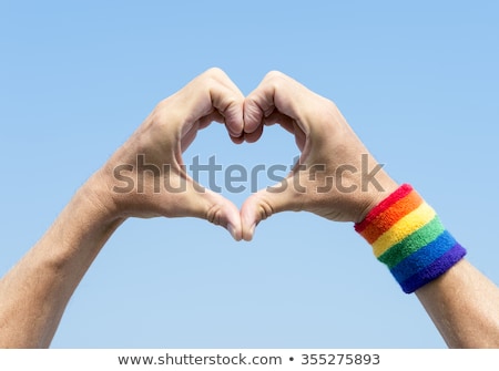 Foto stock: Hand With Gay Pride Rainbow Flags And Wristband