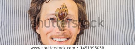 ストックフォト: Young Man Makes A Face Mask With Snail Mucus Snail Crawling On A Face Mask Spa For Man Spa For Al