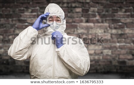 ストックフォト: Chinese Man Wearing Hazmat Suit Goggles And Mask With Brick Wal