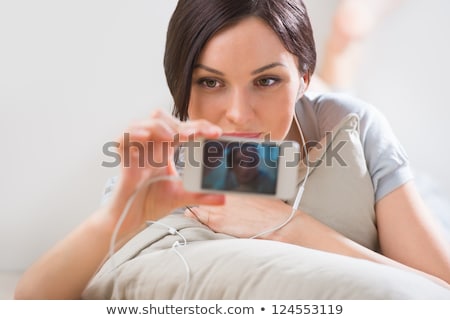ストックフォト: A Young Woman Lying On The Floor With Her Phone And Shooting P