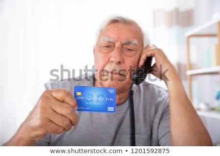 Stock photo: Man With Credit Card Using Landline Phone