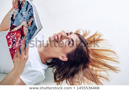 [[stock_photo]]: Brunette With A Magazine Lying On A Carpet