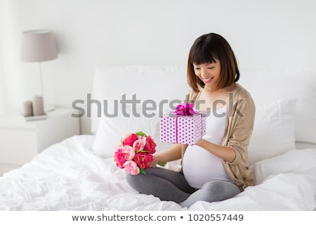 Foto stock: Happy Asian Pregnant Woman With Gift And Flowers