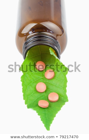 Stock fotó: Leaf And Pills In A Small Bottle Against A White Background