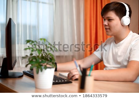 Stok fotoğraf: A Young Man Sits In The Office At A Computer Desk Looks At The Globe And Thinks