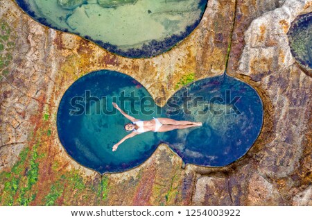 Foto d'archivio: Female Floating In Idyllic Ocean Rock Pool Just Bliss