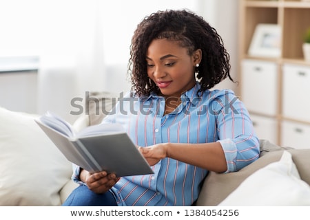 Stock photo: Pretty Young Woman Reading Book On Sofa