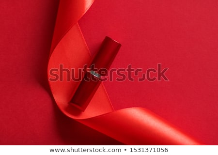 Foto stock: Luxury Lipstick And Silk Ribbon On Red Holiday Background Make 