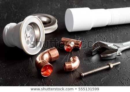 Foto stock: A Plumber With Copper Pipes And A Wrench