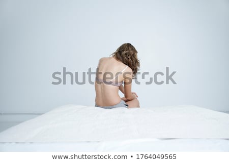 Stock fotó: Back View Of A Young Woman In Underwear Sitting On Bed