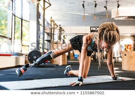 Stok fotoğraf: Disabled Sports Woman Make Sport Stretching Exercises In Gym