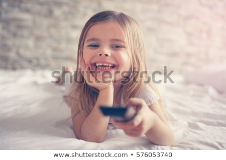 Stockfoto: Cute Little Girl With Remote Control In Front Of Tv