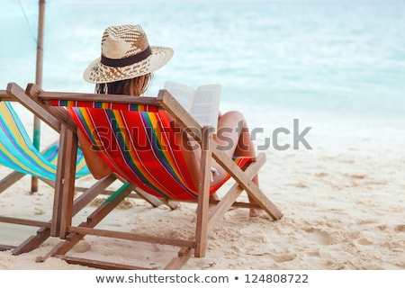 Attractive Woman Reading A Book On A Beach Foto stock © luckyraccoon