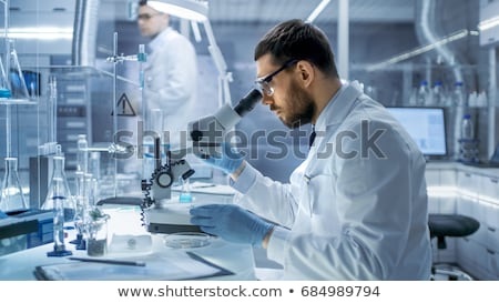 Stok fotoğraf: Scientist Examining Liquid In Beakers