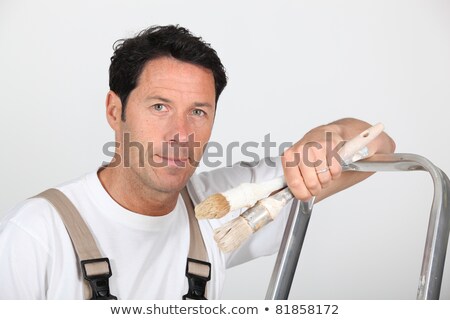 Сток-фото: A Painter And Decorator Leaning Against A Ladder And Looking At Us