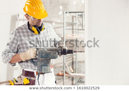 Foto stock: Builder Using A Masonry Drill