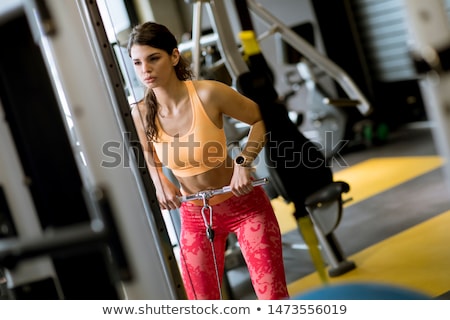 Stok fotoğraf: Woman Using Straight Bar Cable To Pull Up Weights To Exercise Bi