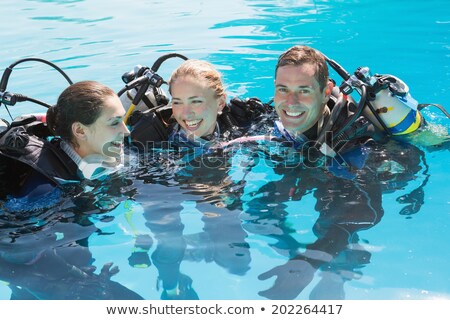 Stockfoto: Smiling Friends On Scuba Training In Swimming Pool