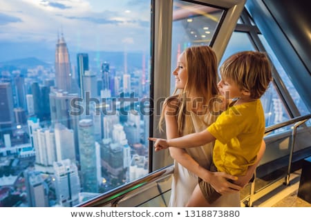 Stockfoto: Mom And Son Are Looking At Kuala Lumpur Cityscape Panoramic View Of Kuala Lumpur City Skyline Eveni