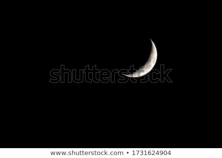 Foto stock: Moon In Waxing Crescent Phase On A Black Background