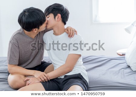 Foto stock: Homosexual Couple Hugging And Relaxing In Bed