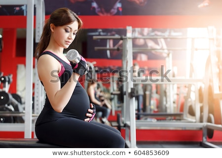 Foto stock: Pregnant Women With Sports Equipment In Gym