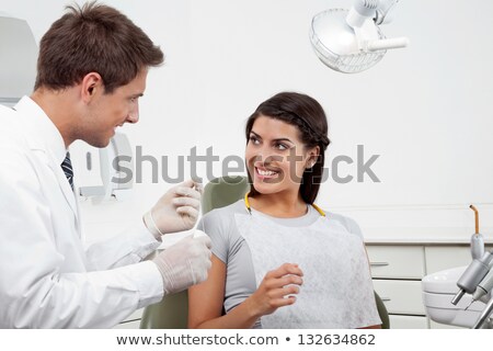 Foto stock: Dentist Holding Tools While Examining Woman At Clinic