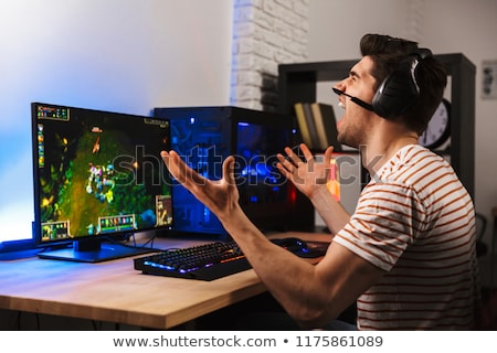 Foto stock: Portrait Of Upset Young Man Wearing Headset Screaming While Sit